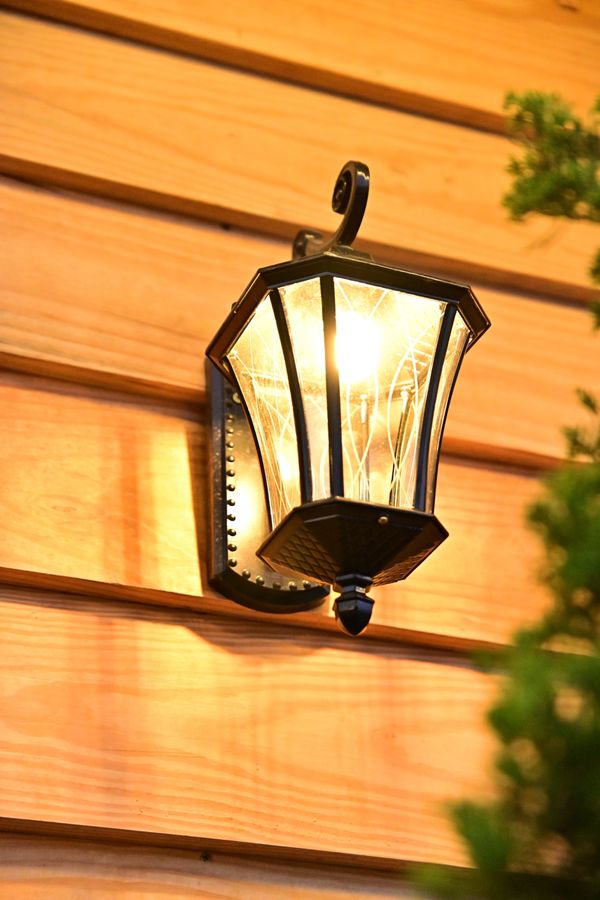 A lit lantern on an exterior wall