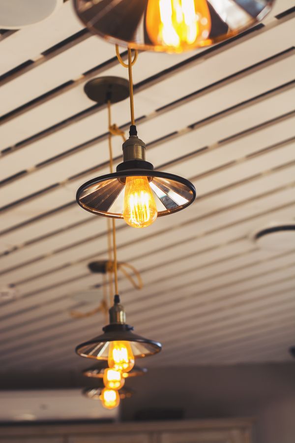 Metal shade pendant lights with glowing filament bulbs