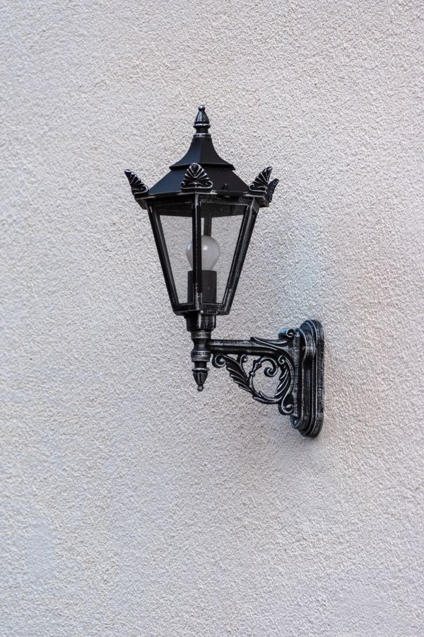 A black lantern-style outdoor wall light