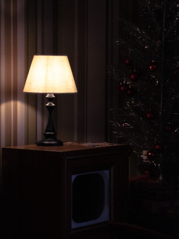 A table lamp with a fabric shade, glowing
